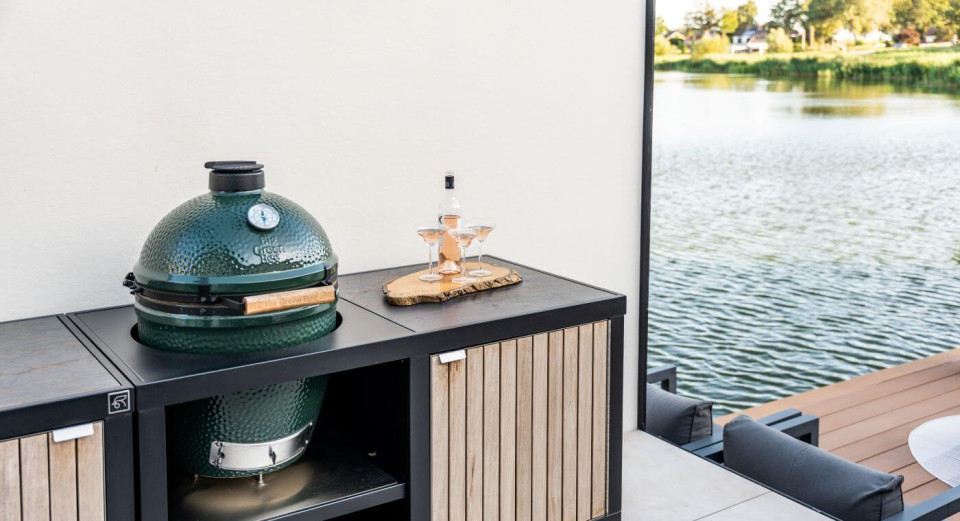 Buitenkeuken van Roostr in industri&euml;le stijl, uitgerust met een Green Egg voor een unieke kookervaring.