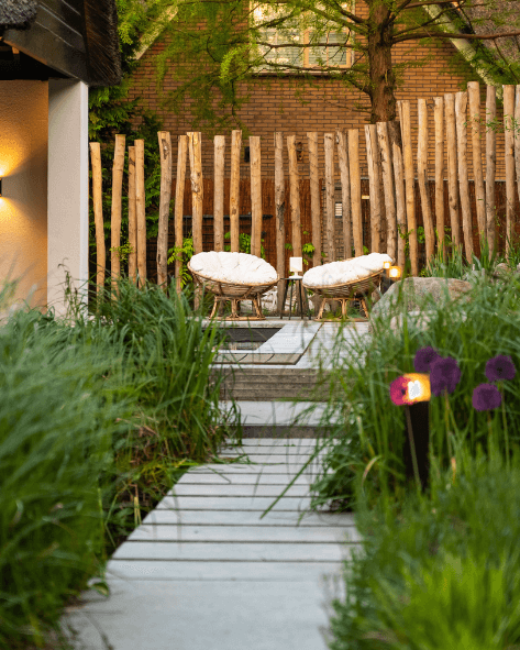 Een moderne achtertuin in Utrecht met robuuste houten palen die een natuurlijke uitstraling geven aan de ruimte.