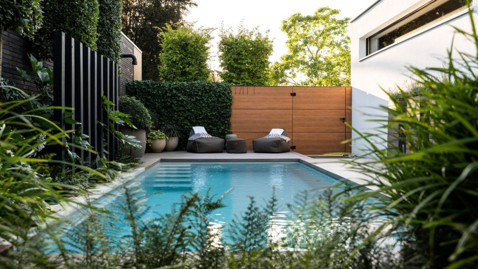 Industri&euml;le stijl tuin met zwembad in luxe achtertuin