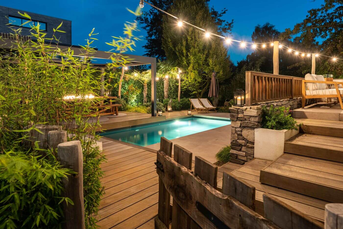 : Bamboehaag en tropische planten creëren privacy in een luxe Balinese achtertuin met zwembad.